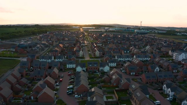 Aerial footage of Sunset at a new housing estate populated by modern townhouses at Waverley housing site- Rotherham Sheffield, South Yorkshire