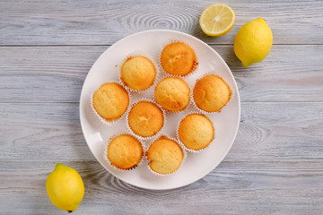 Lemon muffins with coffee on a white wooden table