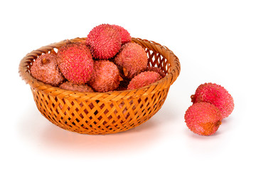 Some fresh litchi fruits or lychee, in wicker bamboo basket isolated on white background, close up