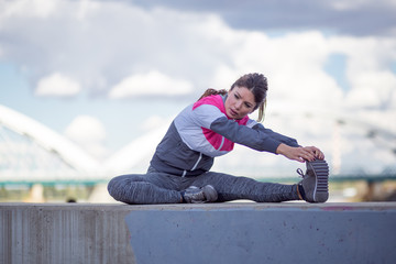 Fototapeta na wymiar Sport and recreation concept.Active woman stretching legs