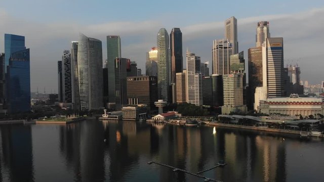Aerial panoramic view of the financial district in Singapore with drone flying backwards while descending slowly