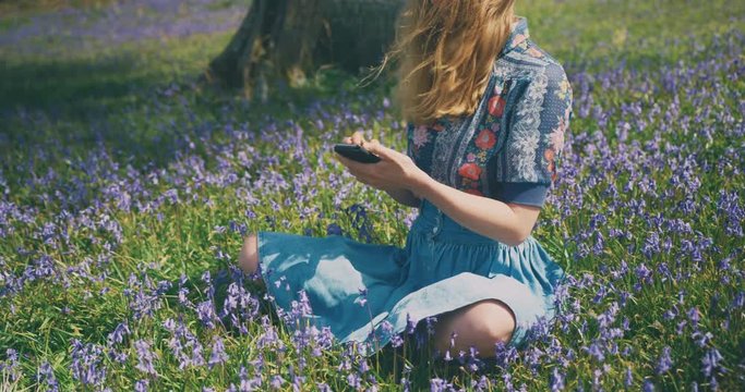 Young woman using smartphone in meadow