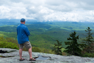 Hiker stops and admires the view at Beacon Heights on the Blue Ridge Parkway in North Carolina.