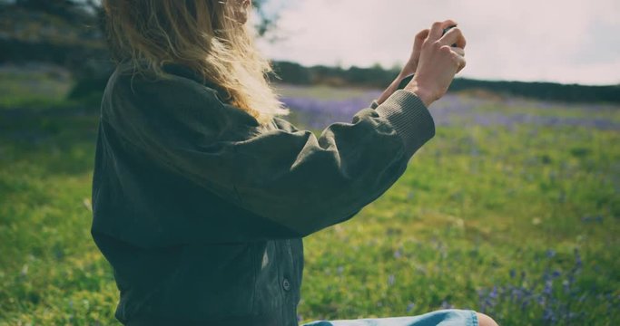 Young woman taking photos in meadow