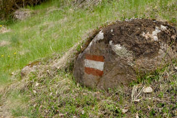 Hiking sign on a stone covered with moss