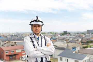 施工管理の男性 腕組みで街並み背景 Wall Mural Wallpaper Murals