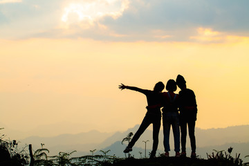 Fototapeta na wymiar Silhouette of happy friends in sunset sky evening time background, Group of young people having fun on summer vacation, Youth lifestyle, party and friendship concept