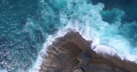 Waves crashing against rocky Australian coastline (aerial view)