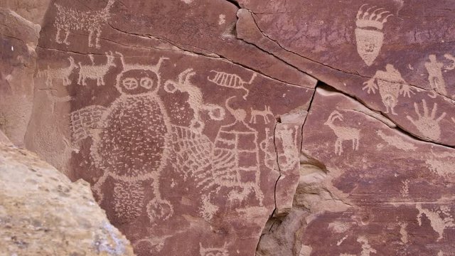 Panning across big petroglyph panel with bear paw with claws and giant owl in Nine Mile Canyon.