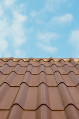 Roof house with tiled roof on blue sky