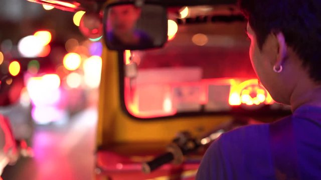 4k footage of Tuk Tuk Driver In Bangkok, Thailand Driving Through A Busy Street