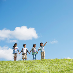 草原で手をつなぐ小学生