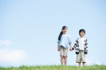 草原で手をつなぐ小学生