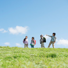 草原で空を見上げる小学生