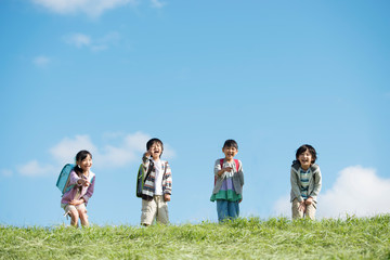 草原ではしゃぐ小学生