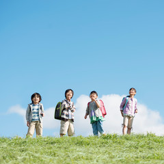 草原で空を見上げる小学生