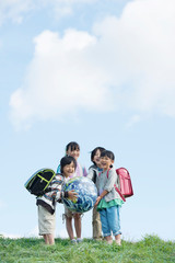 草原で地球のボールを持つ小学生