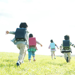 草原を走る小学生の後姿