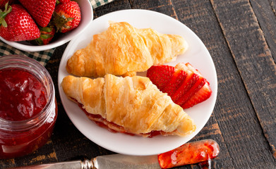 Croissants Filled with Fresh Homemade Strawberry Jam on Wooden Table