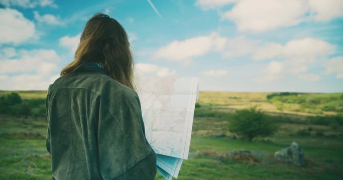 Young woman on the moor studying a map