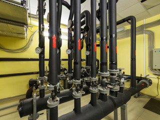 Boiler room inside. Metal pipes with valves and a manometers