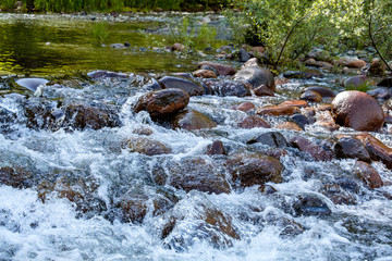 fast water running down rocky creek inside park under the sahde