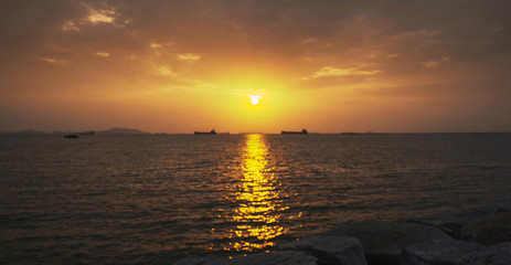 Sunset or sunrise, golden light, natural light in the sea, ocean or lake Cargo ship background