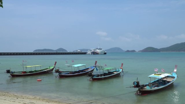 View off the Coast of Phuket Thailand, Thai long tail boats in water on beach