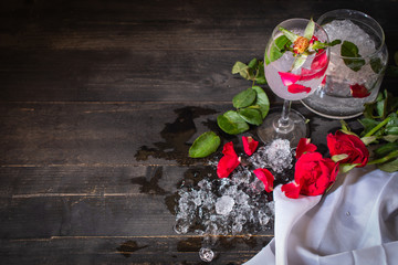 Sparkling cold water detox with rose and ice on the wood table there are rose, diferance glass and...