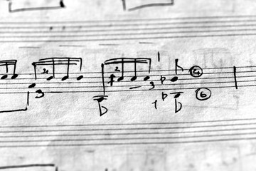 Page of an old musical notebook with hand written notes close up. Black and white