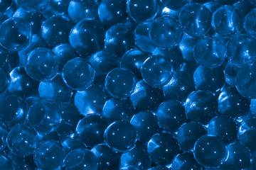 Transparent blue hydrogel balls. Blue water gel balls with bokeh. Polymer gel Silica gel. Liquid...
