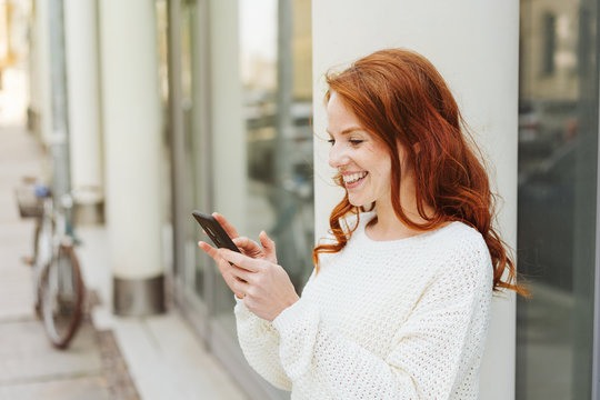 Happy young woman texting a message