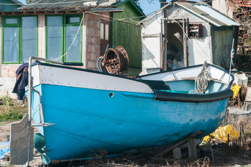 Fototapeta na wymiar Small fishing boat closeup on the dock among fishing village bungalows