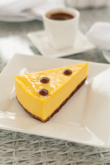 Fresh piece of mango cheesecake on white plate