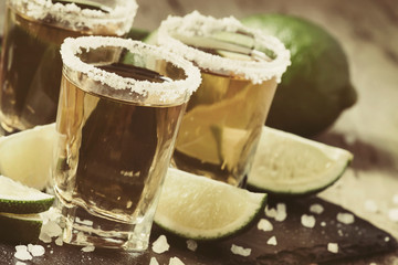 Golden Mexican tequila with lime and salt, selective focus