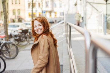 Obraz premium Happy vivacious young woman in a city street