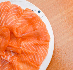 Closeup top view Slided Raw Salmon in white dish on wood blackground