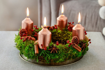 Advent wreath made of moss, cinnamon sticks and rosa canina twigs.