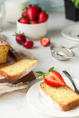 Pound or loaf cake with strawberry and mint on wooden board. Delicious summer dessert.
