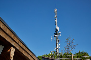 Obraz premium Cell tower at the top of the mountain among the greenery on a summer day