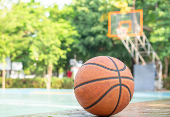Basketball leather on the wooden chair with water droplets Background basketball court and park.