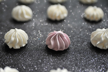 Meringues on glitter black background.