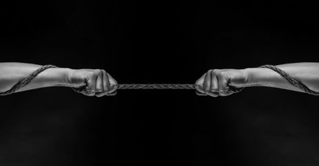Conflict, tug-of-war, rope. Hand holding a rope, climbing rope, strength and determination concept....