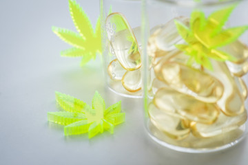 Pillen, Tabletten, Kapseln mit Cannabis Marihuana Hanf und CBD in Labor Becherglas gegen Schmerzen zur Therapie als Medizin 