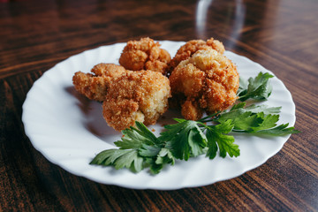fried fresh cauliflower in breadcrumbs closeup on a plate.