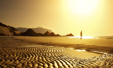 Sunset on a wild beach on the Indian Ocean. Golden sunset on the paradise island beach.