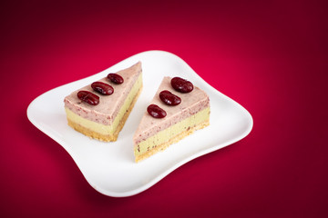 Sliced of Red bean cheese cake on white plate on red Background.