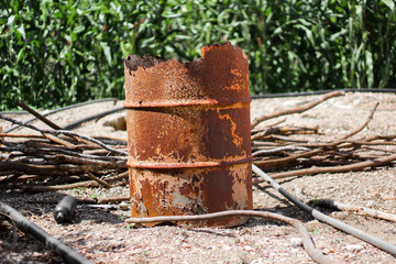 rusty orange metal barrel, old barrel and damaged by moisture and sun