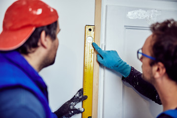 Two handymen working together on a house renovation.