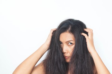 Fototapeta premium Middle aged Asian woman looking at camera worried about damaged hair. Healthy and beauty concept